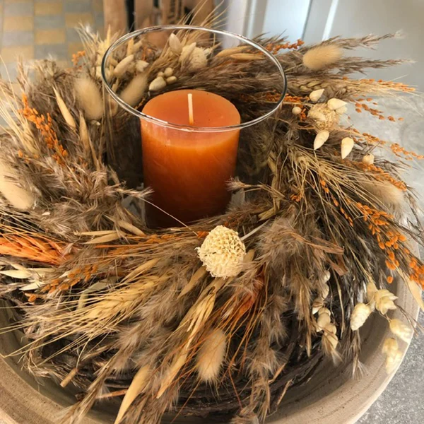 Herbstlicher Dekokranz mit orangener Kerze in der Mitte