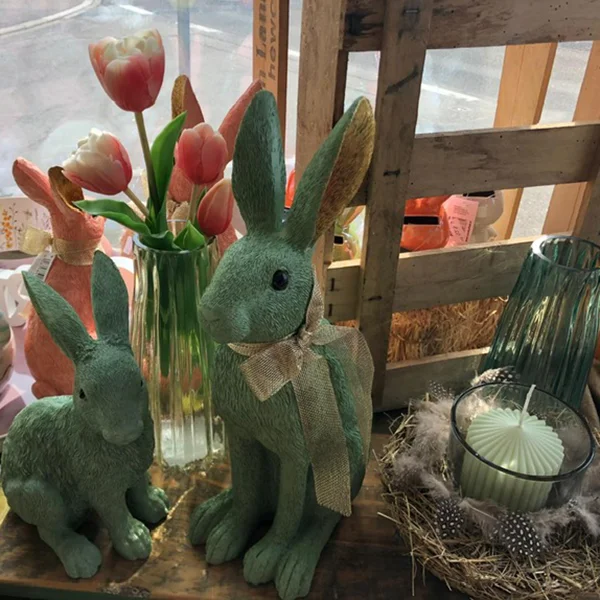 Osterdeko mit grünen Hasen und Tulpen im Schaufenster