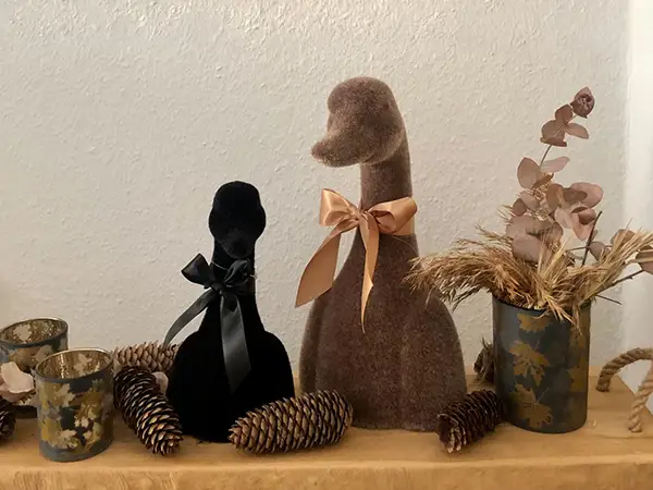 Herbstliche Dekoration mit zwei Stofffiguren, Zapfen und Trockenblumen
